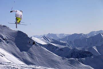 Image showing Freestyle ski jumper with crossed skis