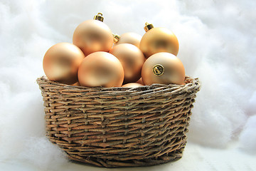 Image showing Golden Christmas ornaments in a wicker basket