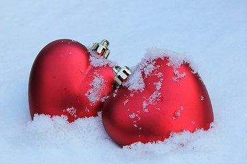 Image showing Two red hearts in the snow