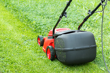 Image showing new lawnmower on green grass
