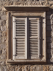 Image showing mediterranean stone window with wood shutters