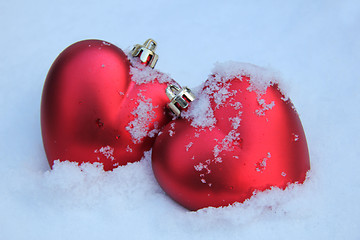 Image showing Two red hearts in the snow