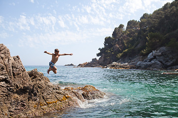 Image showing Young boy jumping into the sea