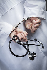Image showing Female Doctor or Nurse In Handcuffs Holding Stethoscope