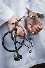 Image showing Female Doctor or Nurse In Handcuffs Holding Stethoscope