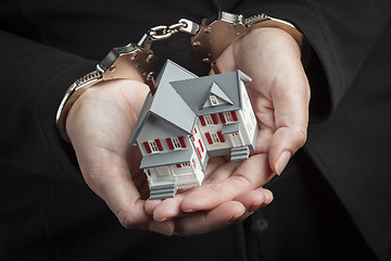 Image showing Woman In Handcuffs Holding Small House