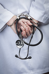 Image showing Female Doctor or Nurse In Handcuffs Holding Stethoscope