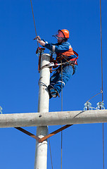 Image showing electrician working on top of an electricity pylon