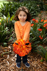 Image showing Beautiful little girll with a bunch of clivia from the garden