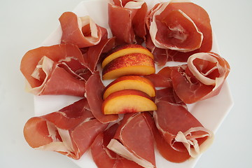 Image showing Spanish Serrano ham and nectarine