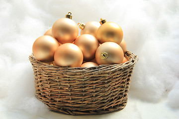 Image showing Golden Christmas ornaments in a wicker basket