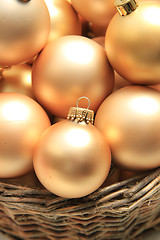 Image showing Golden Christmas ornaments in a wicker basket