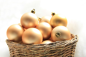 Image showing Golden Christmas ornaments in a wicker basket