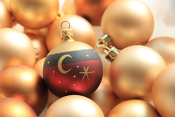 Image showing Red ornament on a pile of golden ornaments