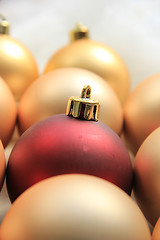 Image showing Red ornament on a pile of golden ornaments