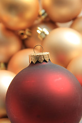 Image showing Red ornament on a pile of golden ornaments