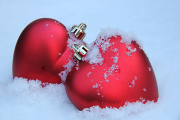 Image showing Two red hearts in the snow