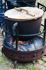 Image showing old pot for cooking over a campfire, close-up. 