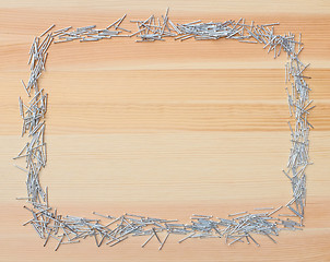 Image showing Metal nails border on wood