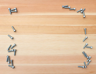 Image showing Socket head bolts as border on wood