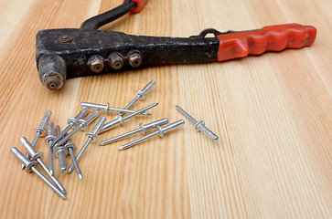 Image showing Closeup of pop rivets and riveter