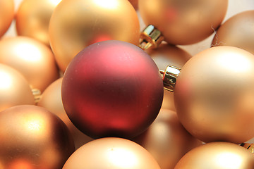 Image showing Red ornament on a pile of golden ornaments