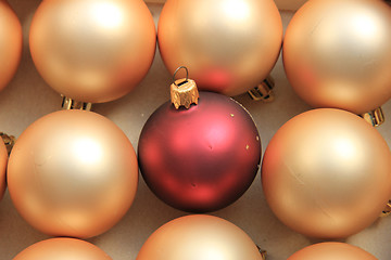 Image showing Red ornament on a pile of golden ornaments