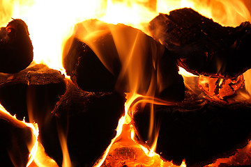 Image showing Glowing wood logs a fireplace