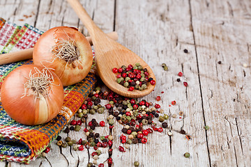 Image showing fresh onions and peppercorns in a spoon 