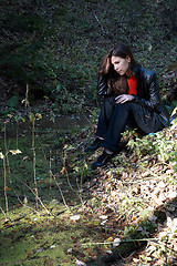 Image showing Girl seating near pond