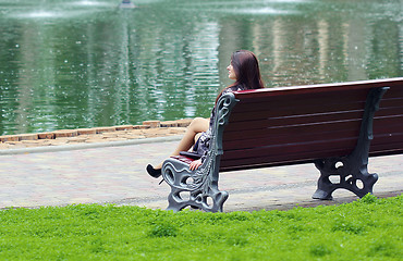 Image showing Woman sitting near the lake