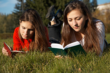 Image showing Girls reading the books on the lawn