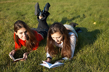 Image showing Girls reading the books on the lawn