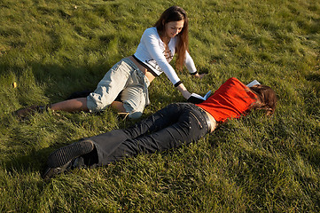 Image showing Girls reading the books on the lawn