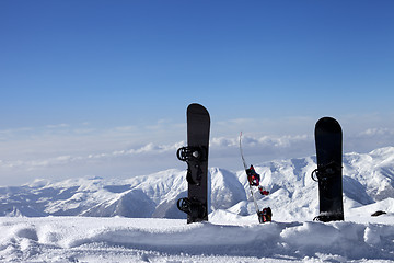 Image showing Three snowboards in snow near off-piste slope in sun day