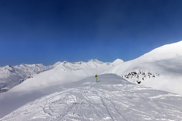 Image showing Warning sing on ski slope and snowy mountains in sun day