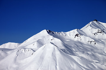 Image showing Snowy winter mountains and clear blue sky in sun day