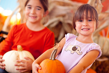 Image showing Cute Little Girls Holding Their Pumpkins At A Pumpkin Patch