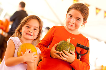 Image showing Cute Little Girls Holding Their Pumpkins At A Pumpkin Patch