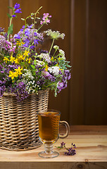 Image showing Bouquet of medicinal herbs in basket and herbal tea
