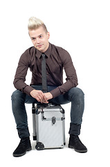 Image showing Handsome man sitting on the suitcase