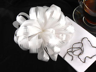 Image showing hot cup of tea with gift bow ribbon
