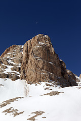 Image showing Snowy rock and cloudless sky with moon