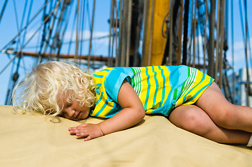 Image showing the little girl fell asleep on the deck of a sailboat  