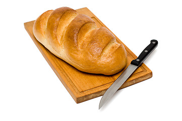 Image showing fresh natural bread with knife on breadboard