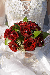 Image showing red roses bouquet in married woman's hand