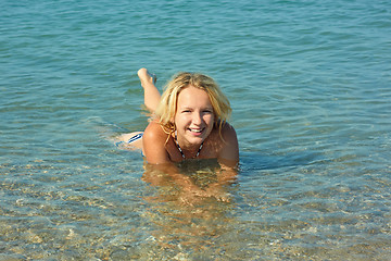 Image showing Teenage girl lying in coastal seawater
