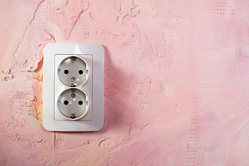 Image showing White socket on pink wall