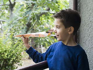 Image showing Kid throws paper plane