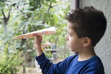 Image showing Kid throws paper plane